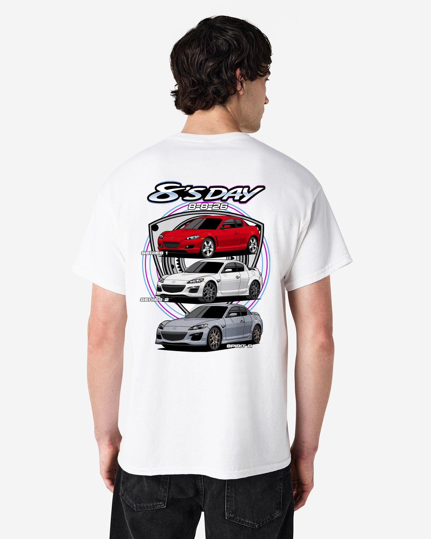 A man viewed from the back wearing a white t-shirt with a large graphic print of three cars (red, white, and silver) and the text '8s DAY' on the back, set against a light studio background.